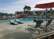 Thumbnail 13 of 36 - Outdoor pool area with lounge chairs at Mission Trails Apartments San Diego, California