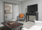Thumbnail 5 of 36 - Living area with TV and sliding glass doors to balcony at Mission Trails Apartments San Diego, San Diego, 92119