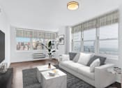 Thumbnail 21 of 50 - Living room with white couch and table with ceiling light at 65 Bay Street, Jersey City, New Jersey