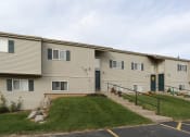 Thumbnail 19 of 22 - Building Exterior with Green Lawn at Stone Hedge Village Townhouses, Farmington, NY 