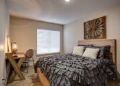 Thumbnail 24 of 50 - Bedroom with cozy bed and lamp at Commons at Redwood Creek Apartments, Beaverton, OR, 97008