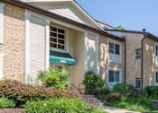 Thumbnail 5 of 23 - A building with a green awning is surrounded by greenery at Potomac Ridge Apartments, Virginia, 22191