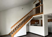 Thumbnail 3 of 21 - A room with a staircase and a ceiling fan.