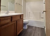 Thumbnail 9 of 21 - A bathroom with a toilet, sink, and shower.
