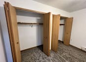 Thumbnail 6 of 21 - A room with a closet and a carpet.