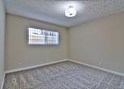 Thumbnail 21 of 28 - A room with a carpeted floor and a window with blinds.