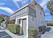 Thumbnail 25 of 28 - A white building with a grey roof and a grey door.