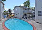Thumbnail 8 of 28 - A small pool in a courtyard surrounded by buildings.