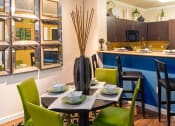 Thumbnail 44 of 55 - a dining area with a table and chairs and a kitchen in the background
