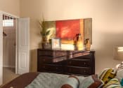 Thumbnail 39 of 55 - a bedroom with a large bed and a dresser with a plant on top of it