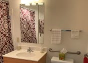 Thumbnail 17 of 17 - A bathroom with a toilet, sink, and a red shower curtain.