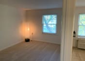 Thumbnail 15 of 17 - A spacious bedroom with a lamp and a window.