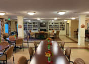 Thumbnail 7 of 17 - A spacious community room with a long table and chairs, a bookcase, and a television.
