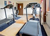Thumbnail 8 of 14 - A gym with treadmills and exercise equipment.