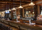 Thumbnail 40 of 40 - Classic bar with wood counter and pendant lighting at The Brook At Columbia Apartments, Columbia