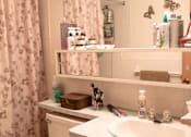 Thumbnail 13 of 33 - a bathroom with a sink, toilet, and a shower curtain