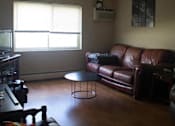 Thumbnail 15 of 18 - a living room with a leather couch, a coffee table, and a tv