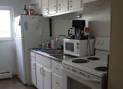 Thumbnail 17 of 18 - a kitchen with a stove, microwave, and refrigerator