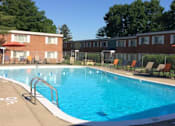 Thumbnail 1 of 27 - a large swimming pool in front of brick apartment buildings
