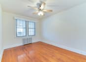 Thumbnail 9 of 16 - vacant bedroom with hardwood flooring, large windows and ceiling fan at 4020 calvert street apartments in washington dc