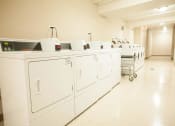 Thumbnail 32 of 37 - Laundry Center with Machines Next to Folding Counter at The Greenway at Carol Stream, Carol Stream
