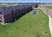 Thumbnail 33 of 34 - exterior, large building, grass, pond, fargo apartment
