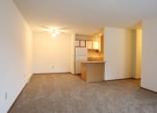 Thumbnail 6 of 18 - Image of a carpeted room and kitchen
