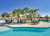 Thumbnail 12 of 32 - Pool side area with tables and chairs at La Contessa Luxury Apartments, Laredo, 78045