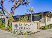 Thumbnail 17 of 23 - A sign for Fairway Villas is in front of a building.