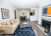 Thumbnail 1 of 11 - View of living room showing fireplace, vaulted ceilings, dining room, and kitchen.