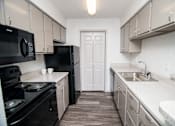 Thumbnail 6 of 11 - Designer kitchen with black appliances and gray cabinetry.