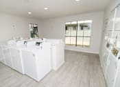 Thumbnail 10 of 11 - Clothing care center showing washing machines and dryers.