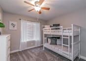 Thumbnail 26 of 39 - Bedroom with large window and ceiling fan in Riata Park Apartment