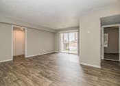 Thumbnail 1 of 28 - Spacious living room with neutral walls and wood-style flooring at Verano Oaks Apartments in Hurst, TX