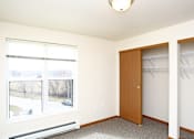 Thumbnail 8 of 12 - A room with a brown door and a window with blinds.