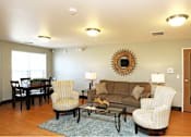Thumbnail 3 of 12 - Community room with a couch, chairs, and a coffee table.