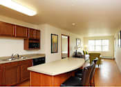 Thumbnail 6 of 12 - A kitchen with wooden cabinets and a white countertop.