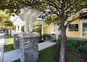 Thumbnail 23 of 26 - Property entrance with stone pillars and white pergola at Liberty Hill Apartments, Draper