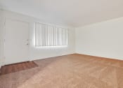 Thumbnail 39 of 48 - Living room with carpeted floors, wood style floors on the door entry area