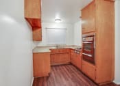 Thumbnail 45 of 48 - Kitchen with stainless steel Microwave oven,  gas cooktop, quartz countertops, wood kitchen cabinets, and wood-inspired flooring