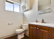 Thumbnail 33 of 48 - Bathroom with wood style single vanity, White single cabinet above the toilet
