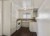 Thumbnail 36 of 48 - Kitchen with white gas range,  granite countertops, white cabinets, and wood-inspired floors