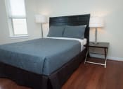 Thumbnail 21 of 25 - a bedroom with a bed and a nightstand