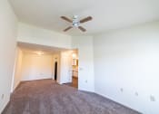 Thumbnail 27 of 35 - Carpeted living room with ceiling fan at Bradford Run in Kokomo, IN