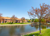 Thumbnail 30 of 35 - Pond view with trees and apartment building at Bradford Run in Kokomo, IN