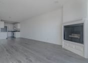 Thumbnail 14 of 30 - Living room with fireplace and kitchen