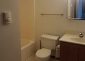 Thumbnail 9 of 15 - A white toilet sits next to a sink in a small bathroom.