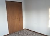 Thumbnail 7 of 15 - A room with a brown door and carpeted floor.