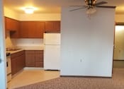 Thumbnail 3 of 15 - A kitchen with a white refrigerator and wooden cabinets.