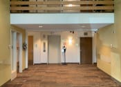 Thumbnail 9 of 13 - Entrance lobby area with a large open space and lofted area to second floor. Elevator can be seen in the background